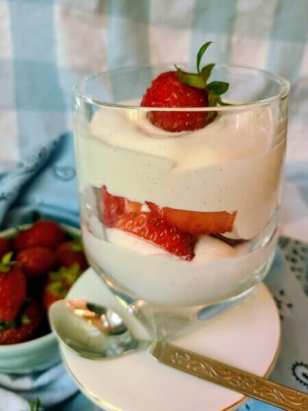 Vegan strawberry parfait with sliced fresh strawberries sandwiched between layets of silky cardamom creme fraiche